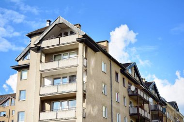 Mavi gökyüzü olan güneşli bir günde modern apartman binaları. Modern bir apartmanın cephesi