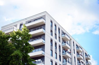 Mavi gökyüzü olan güneşli bir günde modern apartman binaları. Modern bir apartmanın cephesi