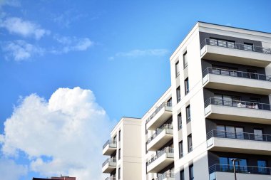 Mavi gökyüzü olan güneşli bir günde modern apartman binaları. Modern bir apartmanın cephesi