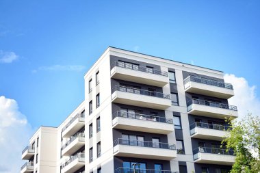 Mavi gökyüzü olan güneşli bir günde modern apartman binaları. Modern bir apartmanın cephesi