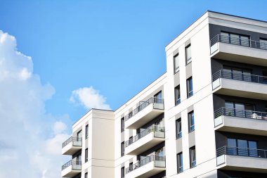 Mavi gökyüzü olan güneşli bir günde modern apartman binaları. Modern bir apartmanın cephesi