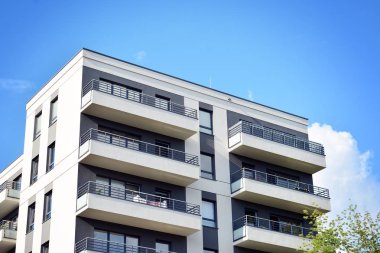 Mavi gökyüzü olan güneşli bir günde modern apartman binaları. Modern bir apartmanın cephesi