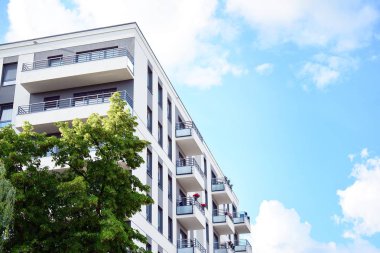 Mavi gökyüzü olan güneşli bir günde modern apartman binaları. Modern bir apartmanın cephesi