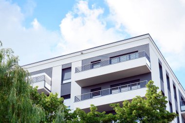 Mavi gökyüzü olan güneşli bir günde modern apartman binaları. Modern bir apartmanın cephesi