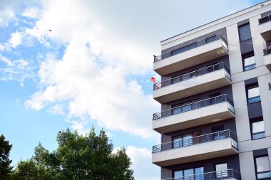 Mavi gökyüzü olan güneşli bir günde modern apartman binaları. Modern bir apartmanın cephesi