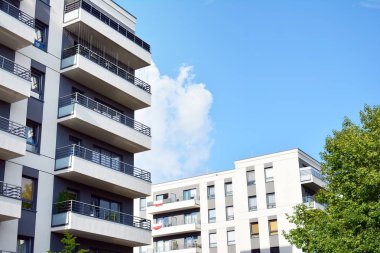 Mavi gökyüzü olan güneşli bir günde modern apartman binaları. Modern bir apartmanın cephesi