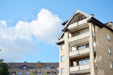 Mavi gökyüzü olan güneşli bir günde modern apartman binaları. Modern bir apartmanın cephesi