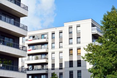 Mavi gökyüzü olan güneşli bir günde modern apartman binaları. Modern bir apartmanın cephesi