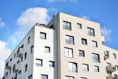 Mavi gökyüzü olan güneşli bir günde modern apartman binaları. Modern bir apartmanın cephesi