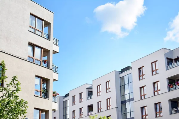 Mavi gökyüzü olan güneşli bir günde modern apartman binaları. Modern bir apartmanın cephesi