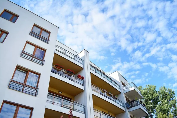 Mavi gökyüzü olan güneşli bir günde modern apartman binaları. Modern bir apartmanın cephesi
