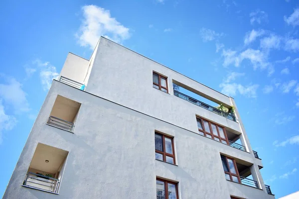 Mavi gökyüzü olan güneşli bir günde modern apartman binaları. Modern bir apartmanın cephesi