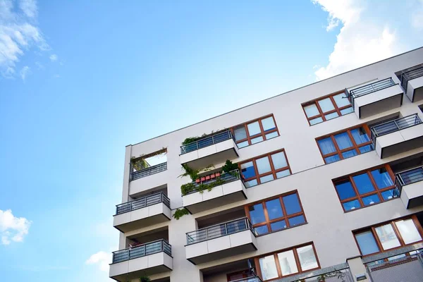 Mavi gökyüzü olan güneşli bir günde modern apartman binaları. Modern bir apartmanın cephesi