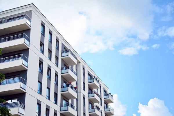 Mavi gökyüzü olan güneşli bir günde modern apartman binaları. Modern bir apartmanın cephesi
