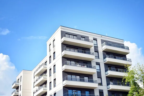 Mavi gökyüzü olan güneşli bir günde modern apartman binaları. Modern bir apartmanın cephesi