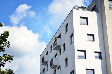 Mavi gökyüzü olan güneşli bir günde modern apartman binaları. Modern bir apartmanın cephesi