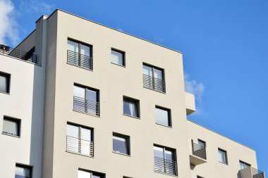 Mavi gökyüzü olan güneşli bir günde modern apartman binaları. Modern bir apartmanın cephesi