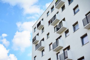 Mavi gökyüzü olan güneşli bir günde modern apartman binaları. Modern bir apartmanın cephesi