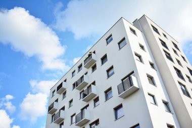 Mavi gökyüzü olan güneşli bir günde modern apartman binaları. Modern bir apartmanın cephesi