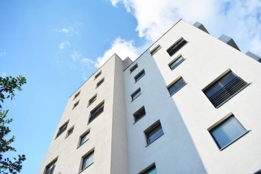 Mavi gökyüzü olan güneşli bir günde modern apartman binaları. Modern bir apartmanın cephesi