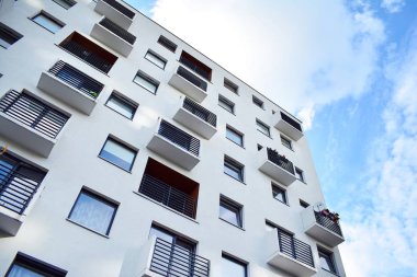 Mavi gökyüzü olan güneşli bir günde modern apartman binaları. Modern bir apartmanın cephesi