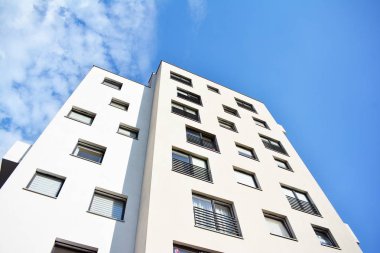 Mavi gökyüzü olan güneşli bir günde modern apartman binaları. Modern bir apartmanın cephesi