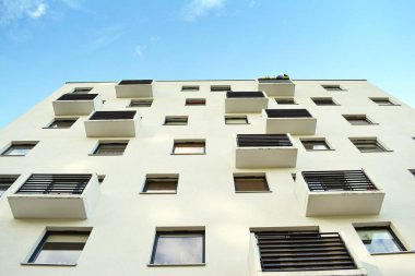 Mavi gökyüzü olan güneşli bir günde modern apartman binaları. Modern bir apartmanın cephesi