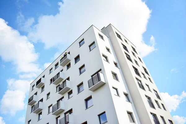 Mavi gökyüzü olan güneşli bir günde modern apartman binaları. Modern bir apartmanın cephesi