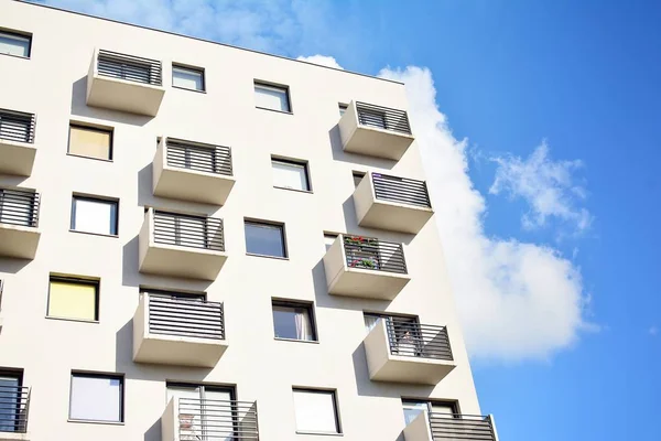 Mavi gökyüzü olan güneşli bir günde modern apartman binaları. Modern bir apartmanın cephesi