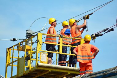 Varşova, Polonya. 23 Temmuz 2018. İnşaat işçileri Varşova Wola istasyonunda yeni Elektrikli çekiş yüklemek