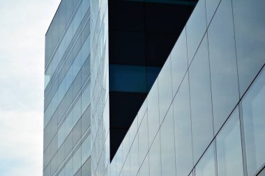 Gökyüzü ve bulutlar üzerinde yansıtılmış cam ile bir bina yansıtan