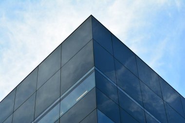 Gökyüzü ve bulutlar üzerinde yansıtılmış cam ile bir bina yansıtan