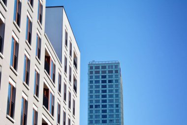 Mavi gökyüzü olan güneşli bir günde modern apartman binaları. Modern bir apartmanın cephesi