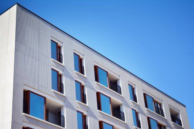 Mavi gökyüzü olan güneşli bir günde modern apartman binaları. Modern bir apartmanın cephesi