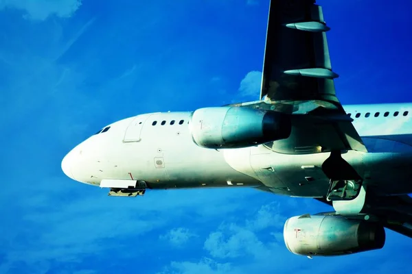 Plane on blue sky. Passenger plane is flying up from runway of airport.