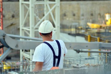 Bir inşaat alanı yürüyüş bir inşaat işçisi, arkadan görünüm