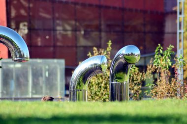 Genel Sanat yükleme önünde modern bina. Dekoratif Paslanmaz çelik borular