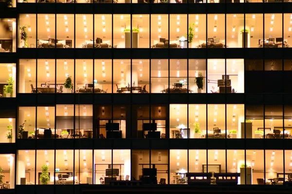 Ofis Binası geceleri. Geç gece iş yerinde. Cam perde duvar ofis binası