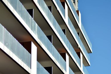 Mavi gökyüzü olan güneşli bir günde modern apartman binaları. Modern bir apartmanın cephesi.