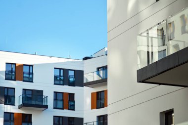 Mavi gökyüzü olan güneşli bir günde modern apartman binaları. Modern bir apartmanın cephesi.