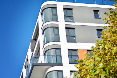 Mavi gökyüzü olan güneşli bir günde modern apartman binaları. Modern bir apartmanın cephesi.