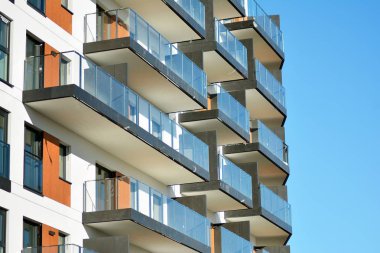 Mavi gökyüzü olan güneşli bir günde modern apartman binaları. Modern bir apartmanın cephesi.