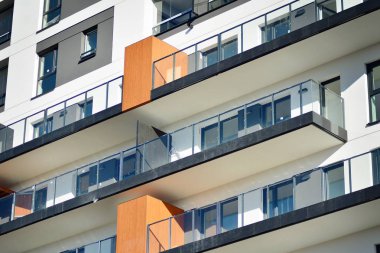Mavi gökyüzü olan güneşli bir günde modern apartman binaları. Modern bir apartmanın cephesi.