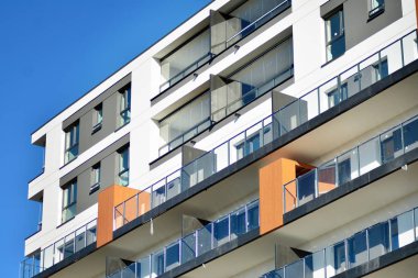 Mavi gökyüzü olan güneşli bir günde modern apartman binaları. Modern bir apartmanın cephesi.