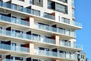 Mavi gökyüzü olan güneşli bir günde modern apartman binaları. Modern bir apartmanın cephesi.