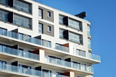 Mavi gökyüzü olan güneşli bir günde modern apartman binaları. Modern bir apartmanın cephesi.