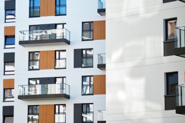 Mavi gökyüzü olan güneşli bir günde modern apartman binaları. Modern bir apartmanın cephesi.