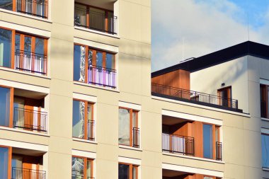 Mavi gökyüzü olan güneşli bir günde modern apartman binaları. Modern bir apartmanın cephesi