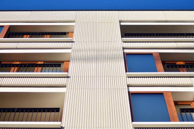 Mavi gökyüzü olan güneşli bir günde modern apartman binaları. Modern bir apartmanın cephesi