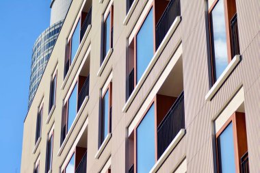 Mavi gökyüzü olan güneşli bir günde modern apartman binaları. Modern bir apartmanın cephesi